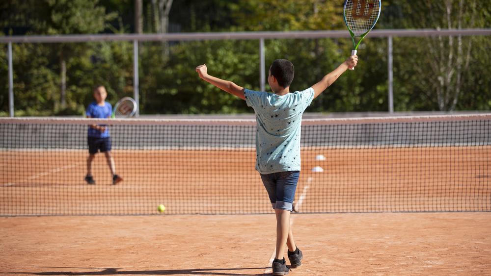 Enfants qui jouent au tennis sur terre battue